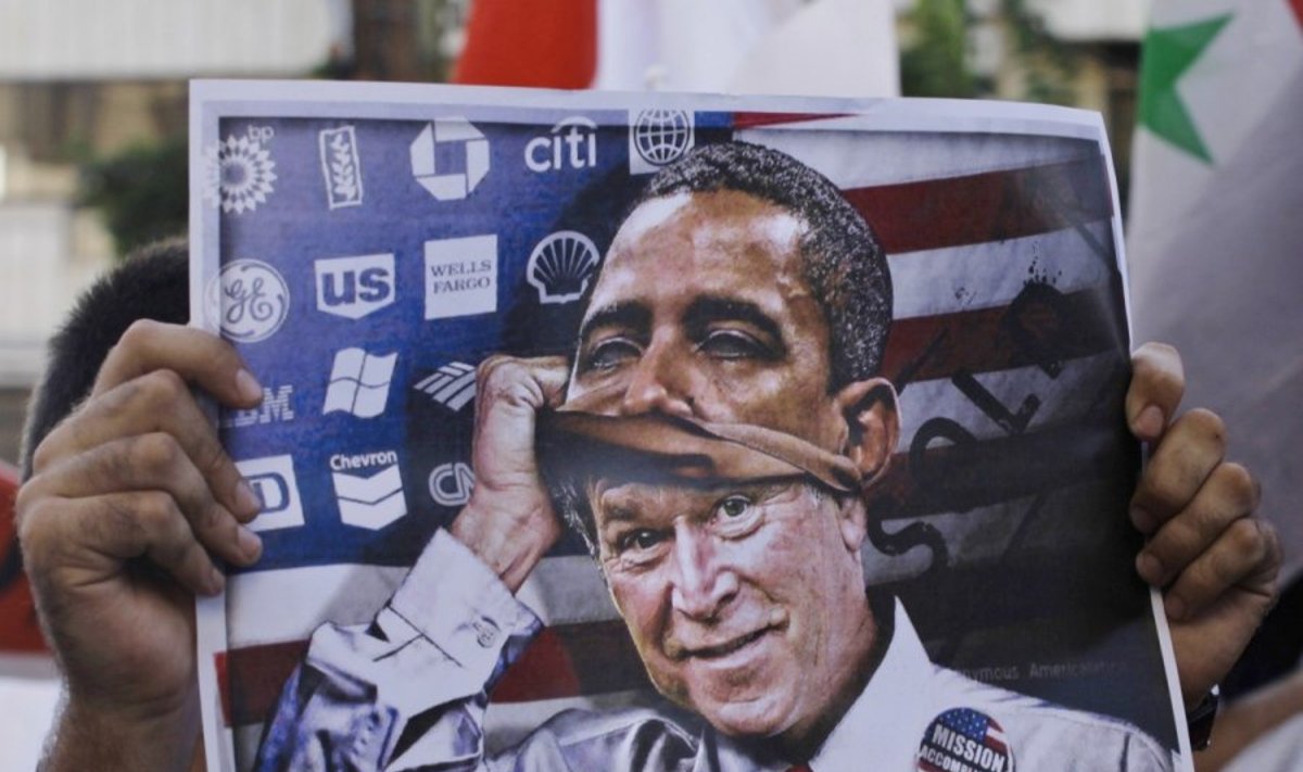 Protestuotojas laiko plakatą su Baracko Obamos atvaizdu