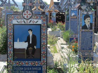 Linksmosios kapinės Sapincos kaime vaizduoja scenas iš mirusių žmonių gyvenimo
