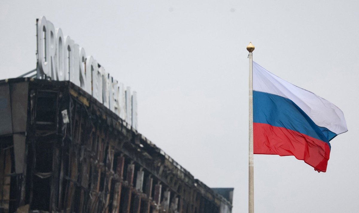 A Russian national tricolor flag flutters in the wind near the burned Crocus City Hall concert hall, the scene of the gun attack, in Krasnogorsk, outside Moscow, on March 23, 2024. Gunmen who opened fire at a Moscow concert hall killed more than 60 people and wounded over 100 while sparking an inferno, authorities said on March 23, 2024, with the Islamic State group claiming responsibility. (Photo by STRINGER / AFP)