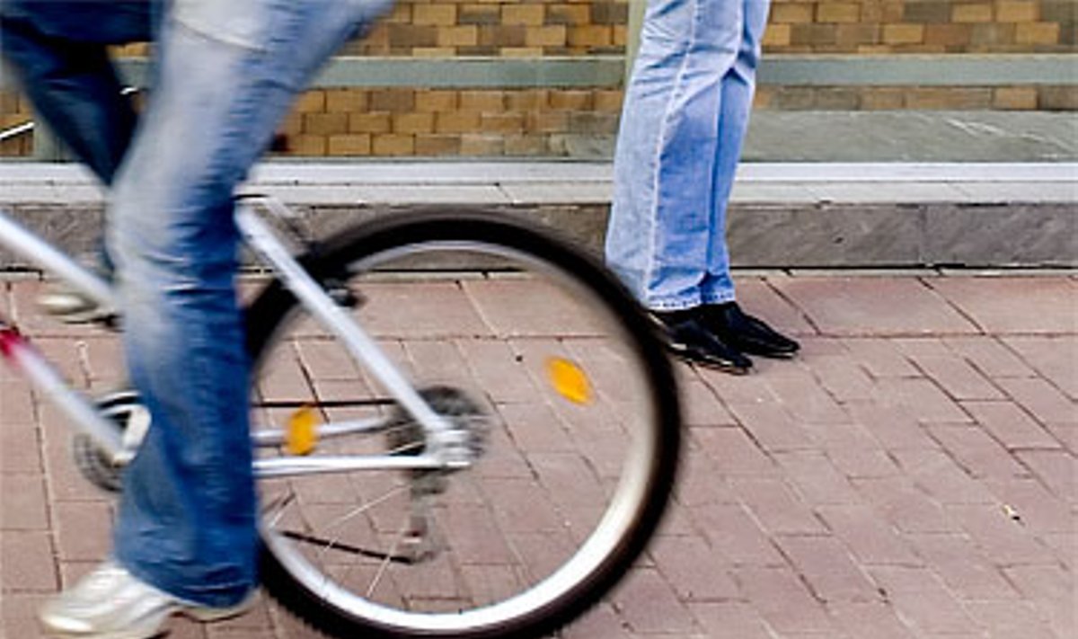 Dviratininkė važiuoja dviračių taku einančiu per Europos aikštės viešojo transporto stotelę.