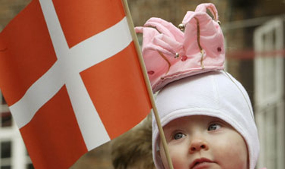 10 mėnesių danė Jozefina, aprengta kaip princesė, laiko rankose Danijos vėliavėlę. 