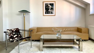 Kailinė Le Corbusier kėdė, dizainas 1929 m. Belgo Chrom kavos staliukas, Itališka sofa, lietuviška Grabausko stiklo skulptūra. Midcentury.lt showroom Vilniuje.