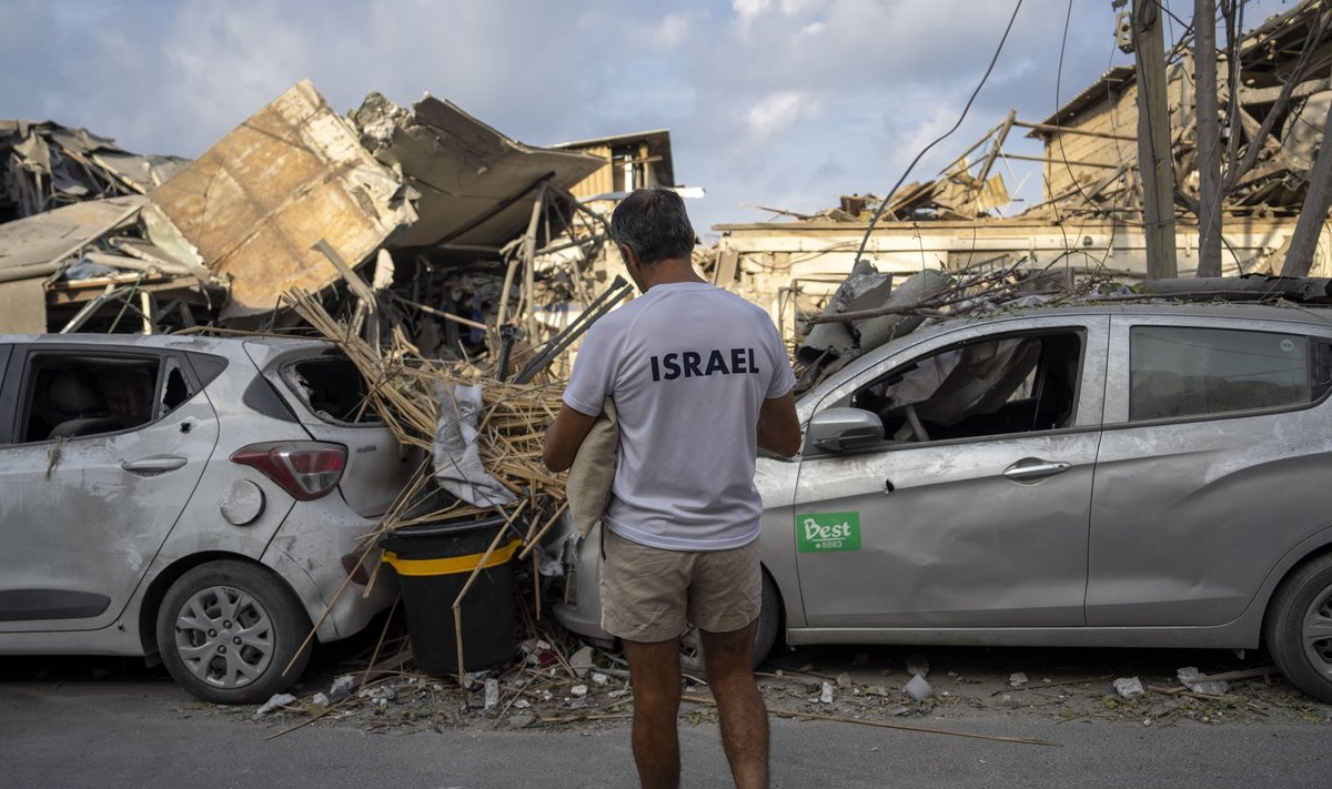 Israelis inspect the rubble of a building a day after it was hit by a rocket fired from the Gaza Strip, in Tel Aviv, Israel, Sunday, Oct. 8, 2023. The militant Hamas rulers of the Gaza Strip carried out an unprecedented, multi-front attack on Israel at daybreak Saturday, firing thousands of rockets as dozens of Hamas fighters infiltrated the heavily fortified border in several locations by air, land, and sea, killing hundreds and taking captives. Palestinian health officials reported scores of deaths from Israeli airstrikes in Gaza. (AP Photo/Oded Balilty)  XOB111