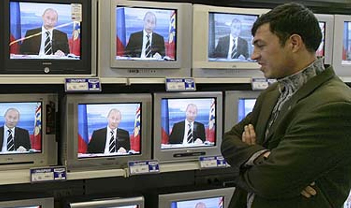 Vyras stebi, kaip Vladimiras Putinas atsakinėja į klausimus
