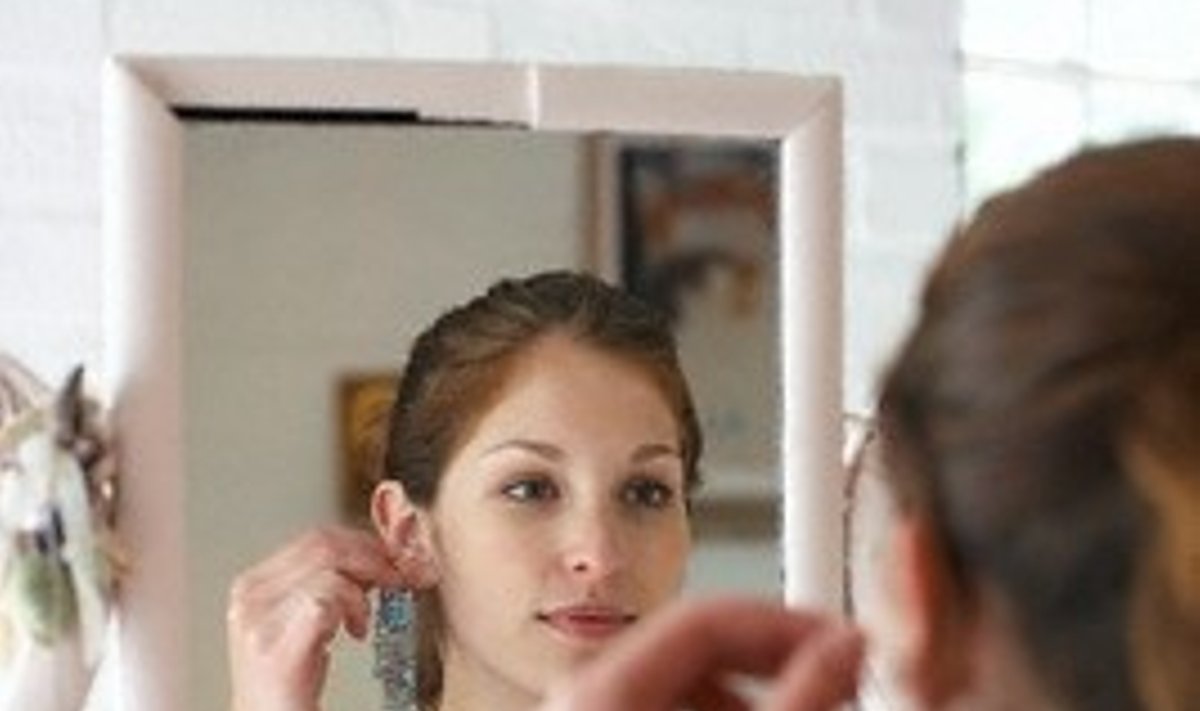 Mergina žvelgia į veidrodį