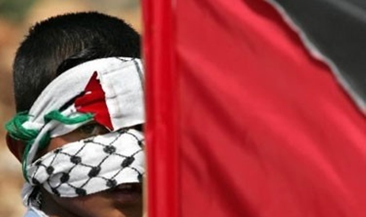 Palestinietis berniukas dalyvauja protesto akcijoje prieš Izraelio statomą sieną Vakarų Krante.