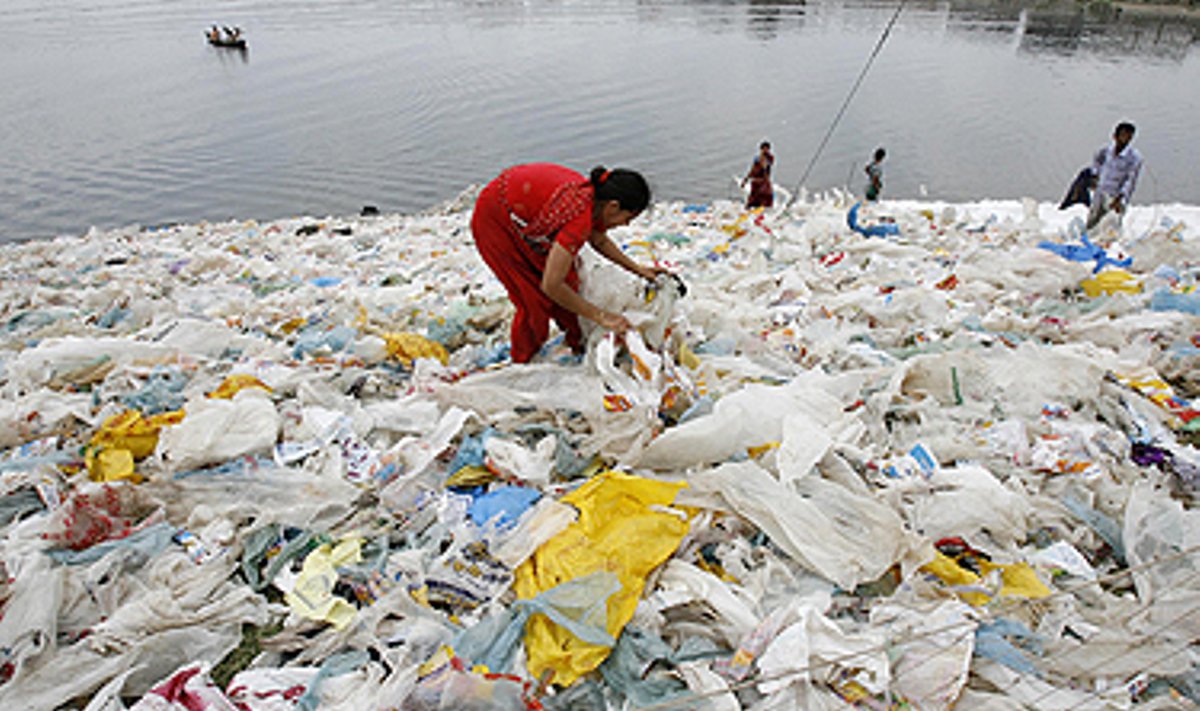 Dhakoje (Bangladešas) moteris upėje plauna perdirbimui skirtus polietileninius maišelius. 