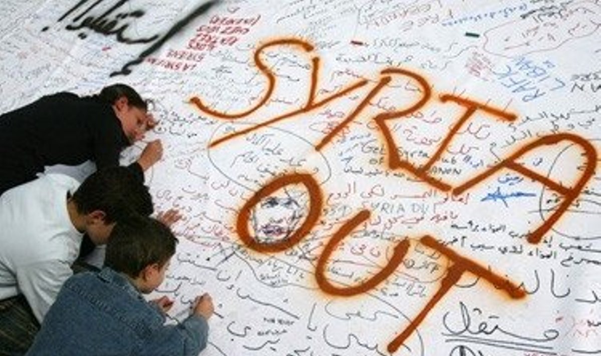 Libane vaikai piešia ant plakato. Užrašas skelbia "Sirija - lauk!"