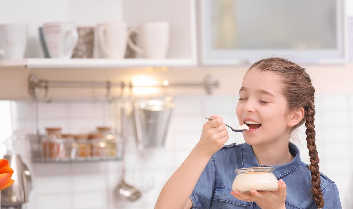Mergaitė valgo graikišką jogurtą