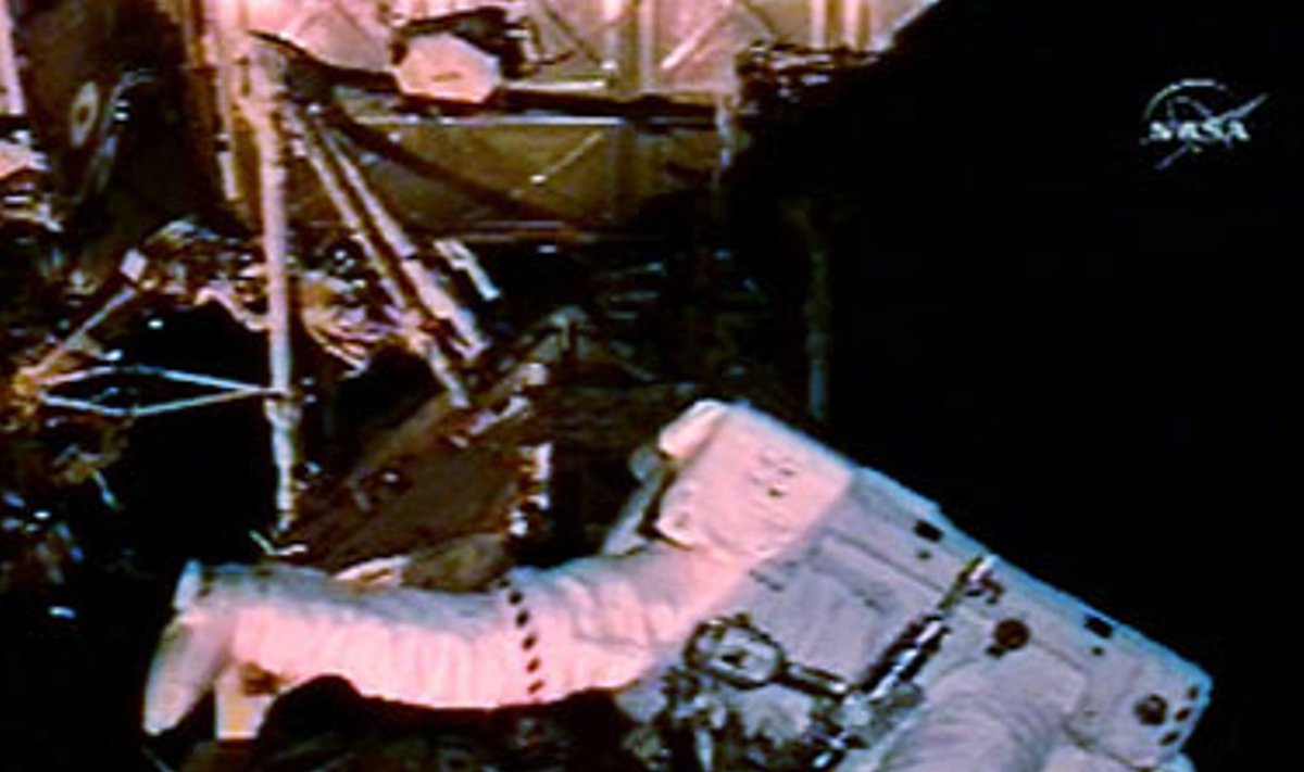 Kanadietis astronautas Stevenas MacLane'as dirba atvirame kosmose.