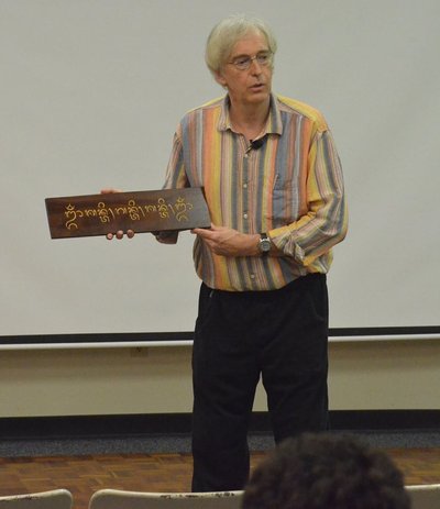 Timas Brookesas su medyje išgraviruotu užrašu baliečių kalba