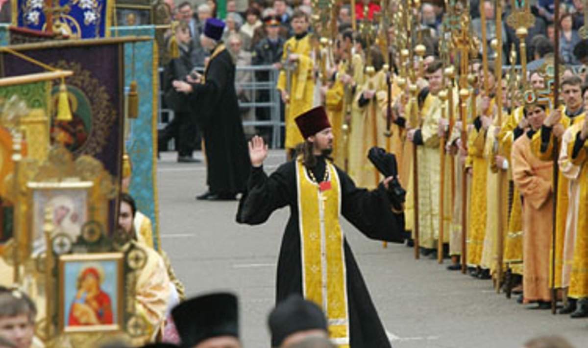 Ortodoksų dvasininkas mosikuoja rankomis eidamas tarp tikinčiųjų kolonų religinės procesijos Maskvoje metu. Gegužės 24-ąją Maskvoje buvo švenčiama Šventojo Kirilo diena.