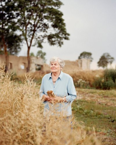 Gražina Linkevičiūtė-Giedraitienė stovi šalia lauko, kuriame kadaise buvo jų šeimos ūkis. Kalevai, Pakruojo rajonas, 2020.