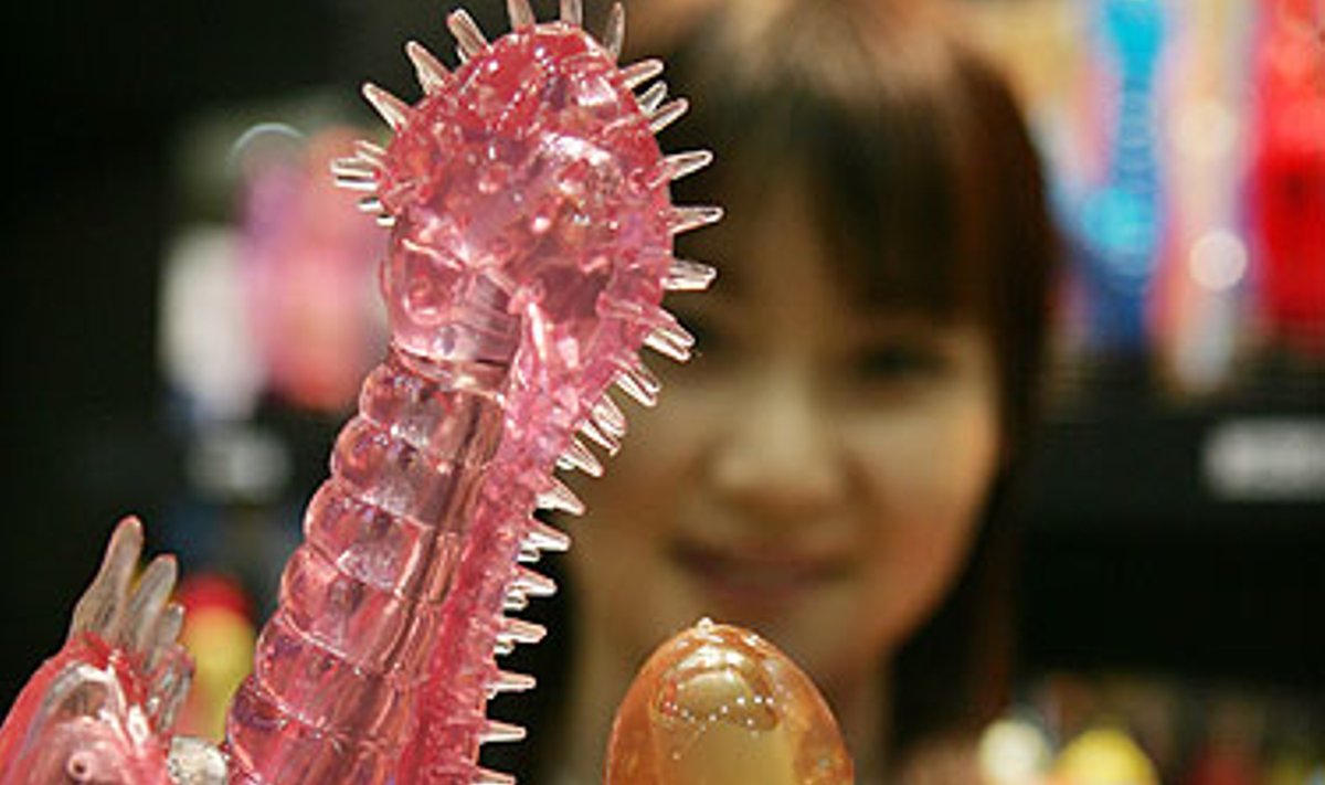 Modelis demonstruoja įvairių spalvų ir formų vibratorius kasmetinėje laisvalaikio parodoje Tokijuje. 