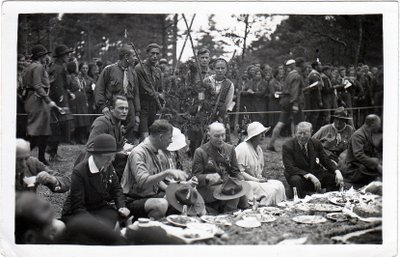 Į skautų sąskrydį Palangoje atvykęs generolas lordas Robertas Baden-Pauelas (centre) su palyda valgo pietus skautų stovykloje. 1933.VIII.17. TIM Fotonuotraukų ir negatyvų rinkinys