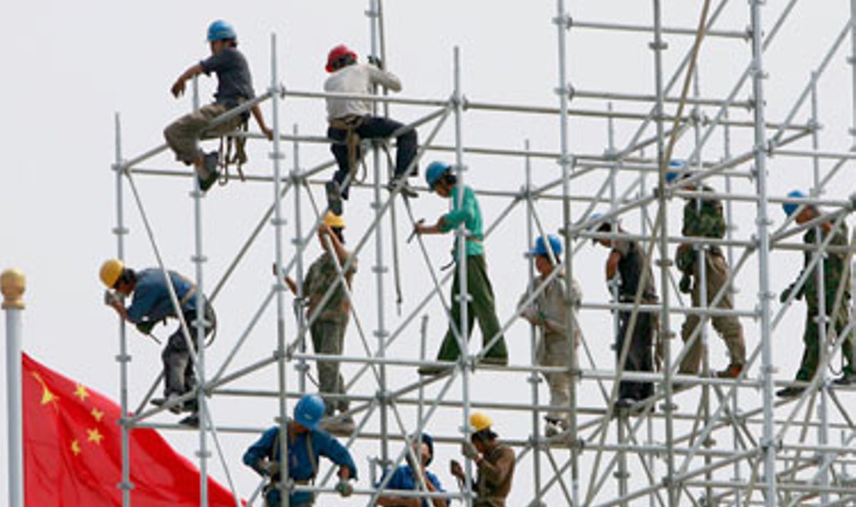 Kinijos darbininkai "Metų iki Pekino olimpiados" šventei montuoja didelę sceną.