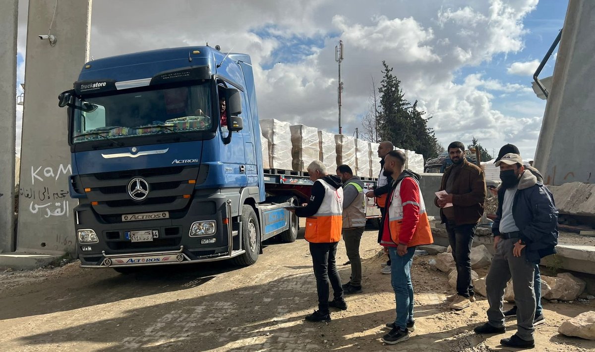 Palestiniečiai priima humanitarinės pagalbos sunkvežimį Rafos pasienio ruože tarp Egipto ir Gazos Ruožo.