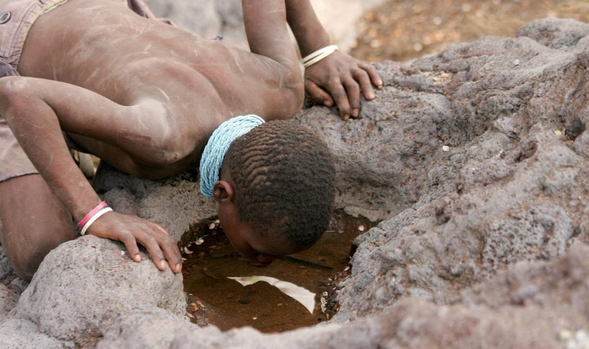 Hadzų genties berniukas geria vandenį