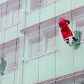 Netradicinis reginys Slovėnijoje: ant stiklinių pastato sienų lipantys Kalėdų seneliai – staigmena sergantiems vaikams