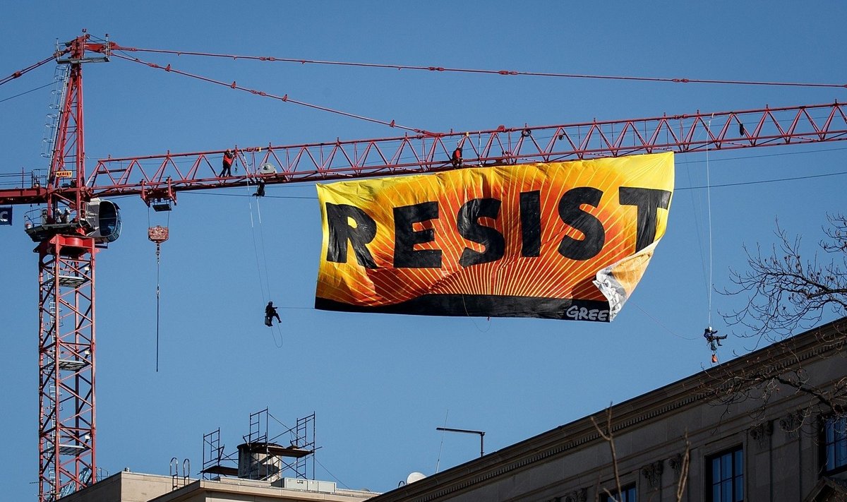 Vašingtono centre protestuotojai plakatu „Resist“ ant krano ragina priešintis Trumpui