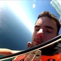 Ekstremalas iš Australijos nuogas šoko parašiutu ir grojo smuiku