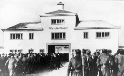 Zachsenhauzeno koncentracijos stovyklos vartai. Kairėje žengia kalinių kolona, dešinėje – SS sargybiniai. Knygos „SS specialioji Dirlewangerio komanda“ iliustracija