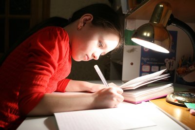 Mergaitė ruošia namų darbus