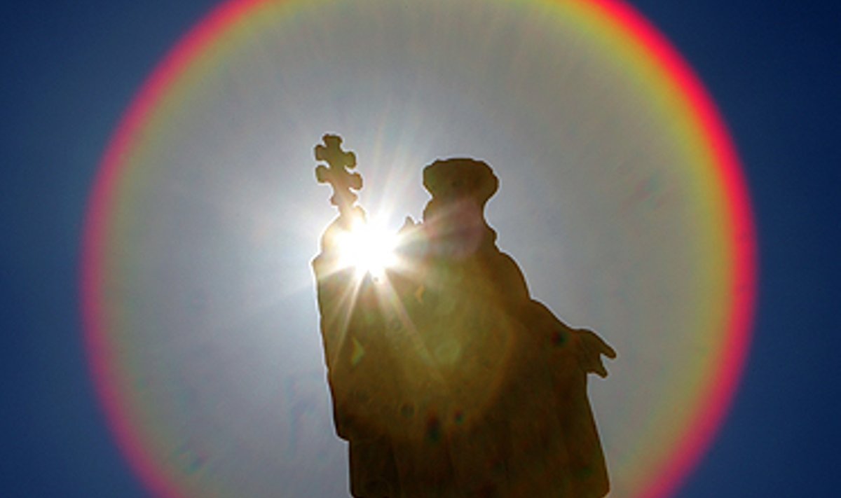 Šv.Petro aikštėje Vatikane saulės aureole apgaubta statula.