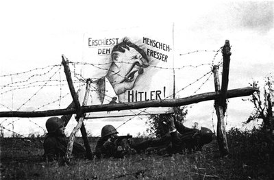 Priešais vokiečių pozicijas iškeltas plakatas: „Šauk į žmogėdrą Hitlerį!“