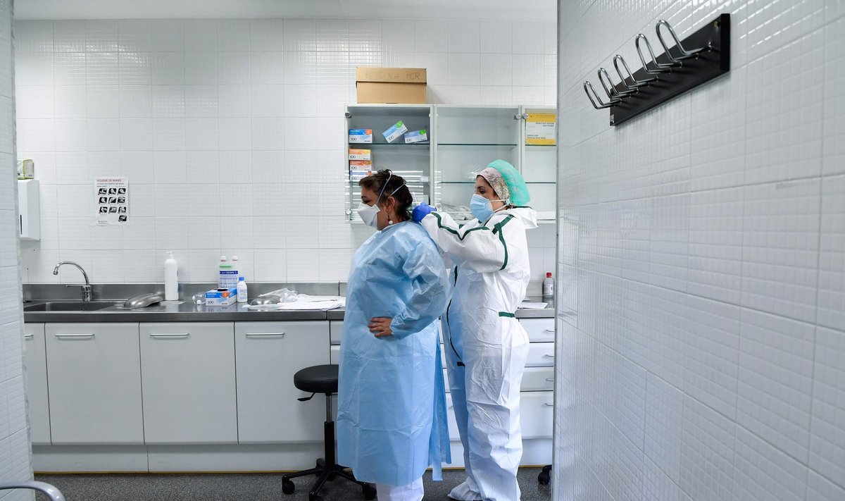 Sveikatos priežiūros darbuotojai ruošiasi rinkti mėginius naujo koronaviruso COVID-19 tyrimų kambaryje pirminės sveikatos priežiūros centre Barselonoje
