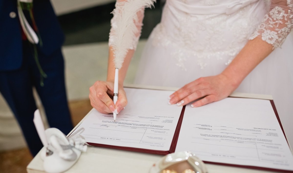 Moteris pasirašo vedybų dokumetus
