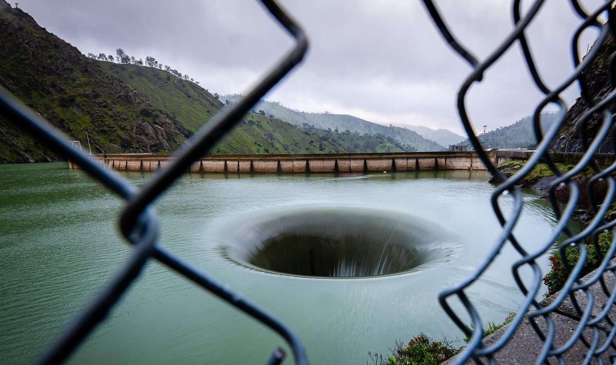Kalifornijoje esančio tvenkinio vanduo nuteka į didelę skylę, žiojinčią marių vandens paviršiuje.