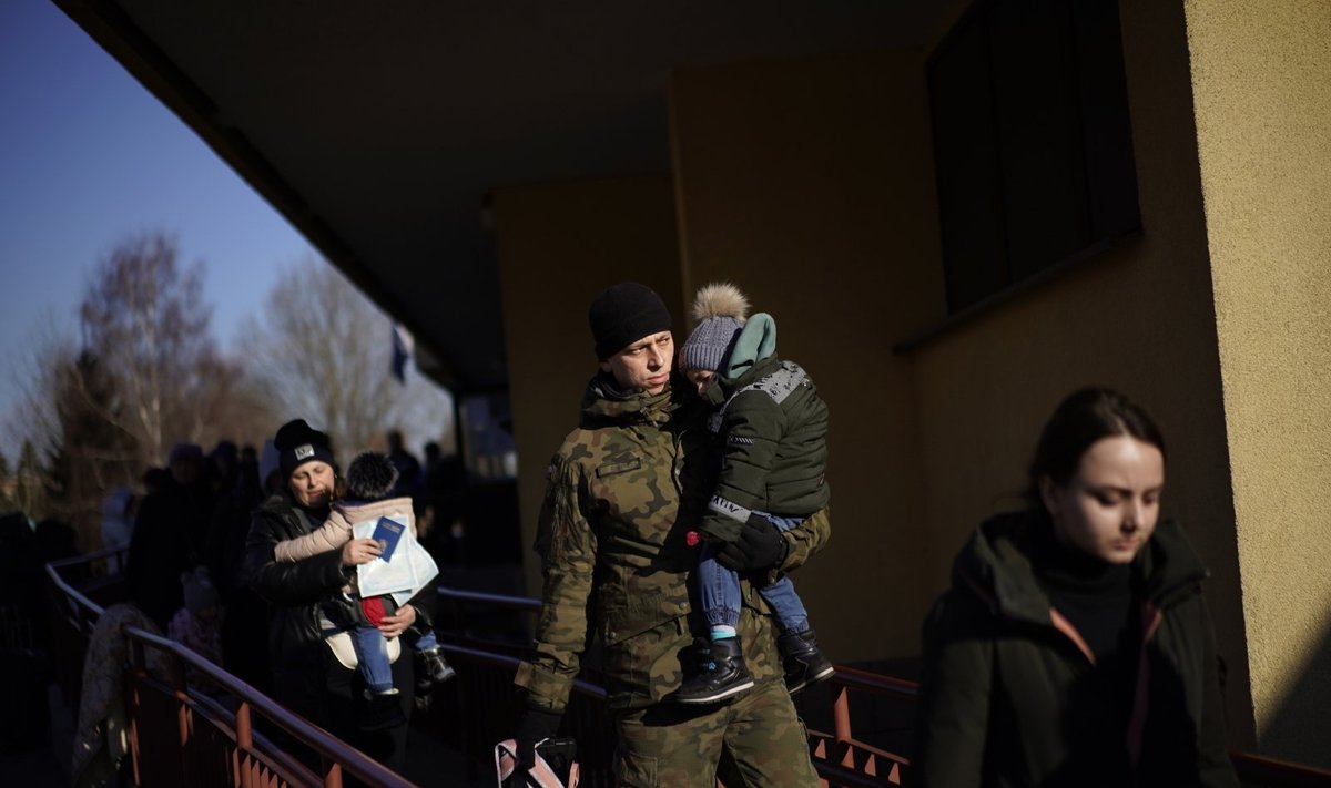Lenkijos kareivis neša ukrainiečių karo pabėgėlių vaiką
