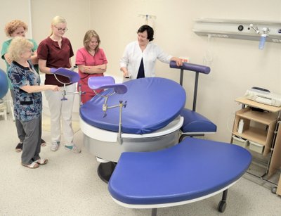 Apvali daugiafunkcinė lova, leidžianti pacientei pasirinkti patogiausią gimdymo padėtį