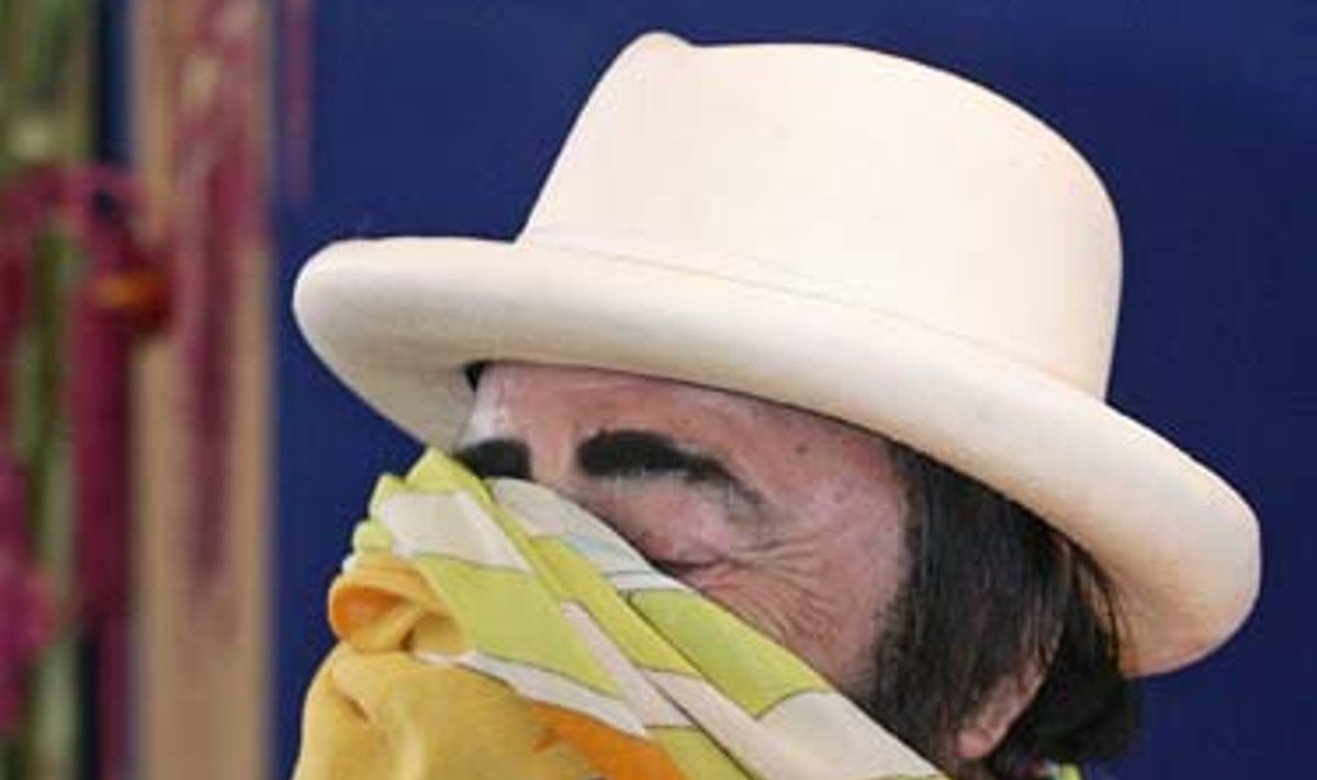 Žymusis Italijos tenoras Luciano Pavarotti (Lučianas Pavarotis), užsidengęs veidą skara, rugpjūčio 19 dieną pokštauja per spaudos konferenciją Hamburge (Vokietijoje). 