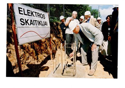 Elektroninių elektros energijos skaitiklių antro korpuso statybos pradžia 1998 m.,  Įmonės valdybos Pirmininkas Leonas Ašmantas, už jo – ekonomikos ministras V.Babilius (su šalmu)