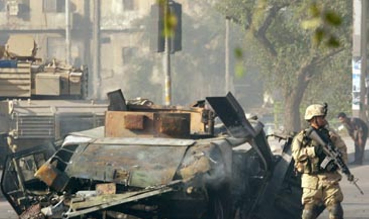 JAV kariai Bagdade saugo sukilėlių susprogdintą armijos visureigį "Humvee".