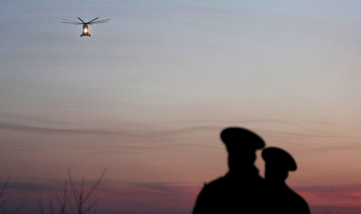 Rusijos kariškiai stebi sraigtasparnį, gabenantį žuvusiuosius prie Smolensko