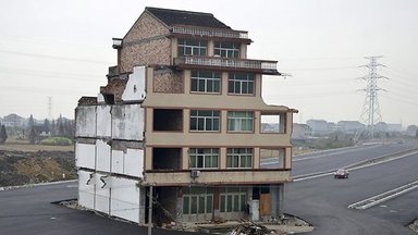 В Китае посреди дороги стоит полуразрушенный дом