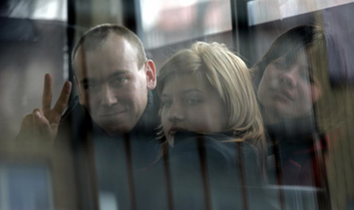 Uždaryti areštinėje piketuotojai, protestuojantys prieš prezidento rinkimų rezultatus Minske, sveikinasi su jų palaikyti atėjusiais žmonėmis pro langą. 
