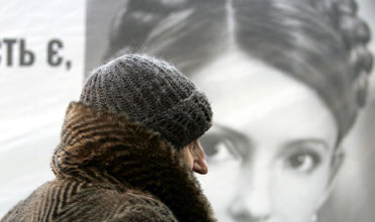 Pagyvenusi moteris eina pro Julijos Tymošenko rinkiminį plakatą Kijevo (Ukraina) centre.
