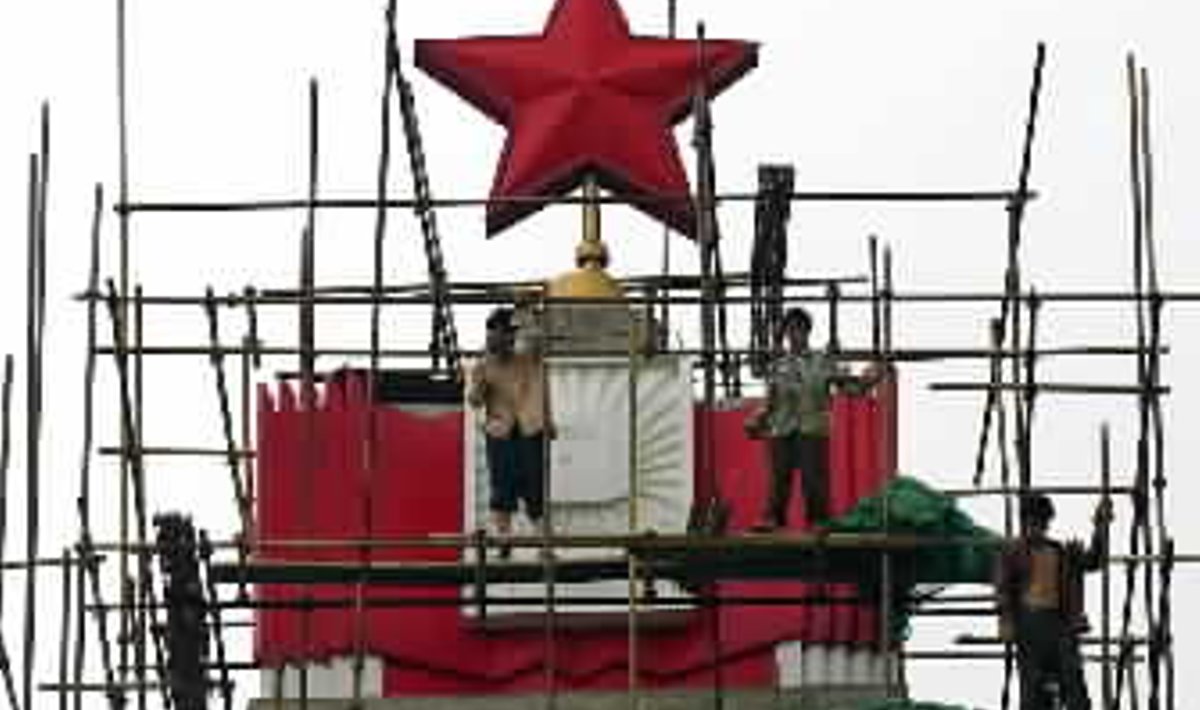 Kinų darbininkai atnaujina paminklą, skirta atminti sunkią kovą su 1954 m. užklupusiais potvyniais centrinėje Kinijoje.