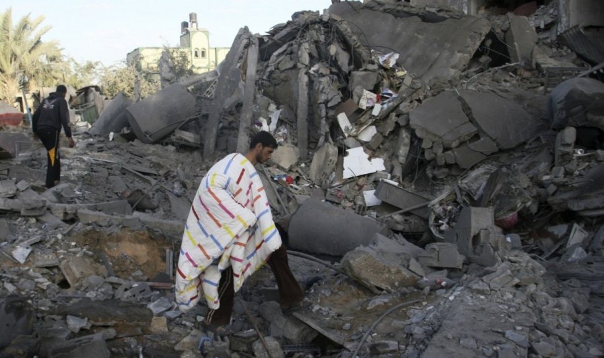 Palestinietis renka daiktus iš Izraelio atakuoto Hamas karinio lyderio Attia Abu Inkara namo