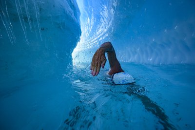 Vyras plaukia tarp Antarktidos ledynų