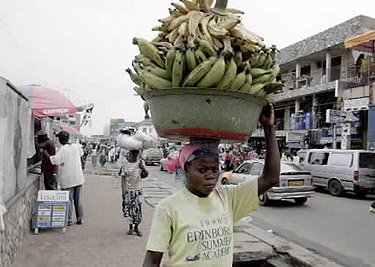 Jauna mergina neša indą, pilną bananų, Gana. 