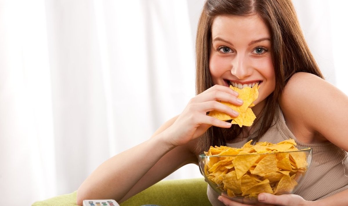 Paauglė, mergina valgo bulvių traškučius, nesveika mityba