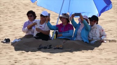 Karščio banga šiaurės vakarų Kinijos dykumoje traukia turistus pasimėgauti smėlio terapija