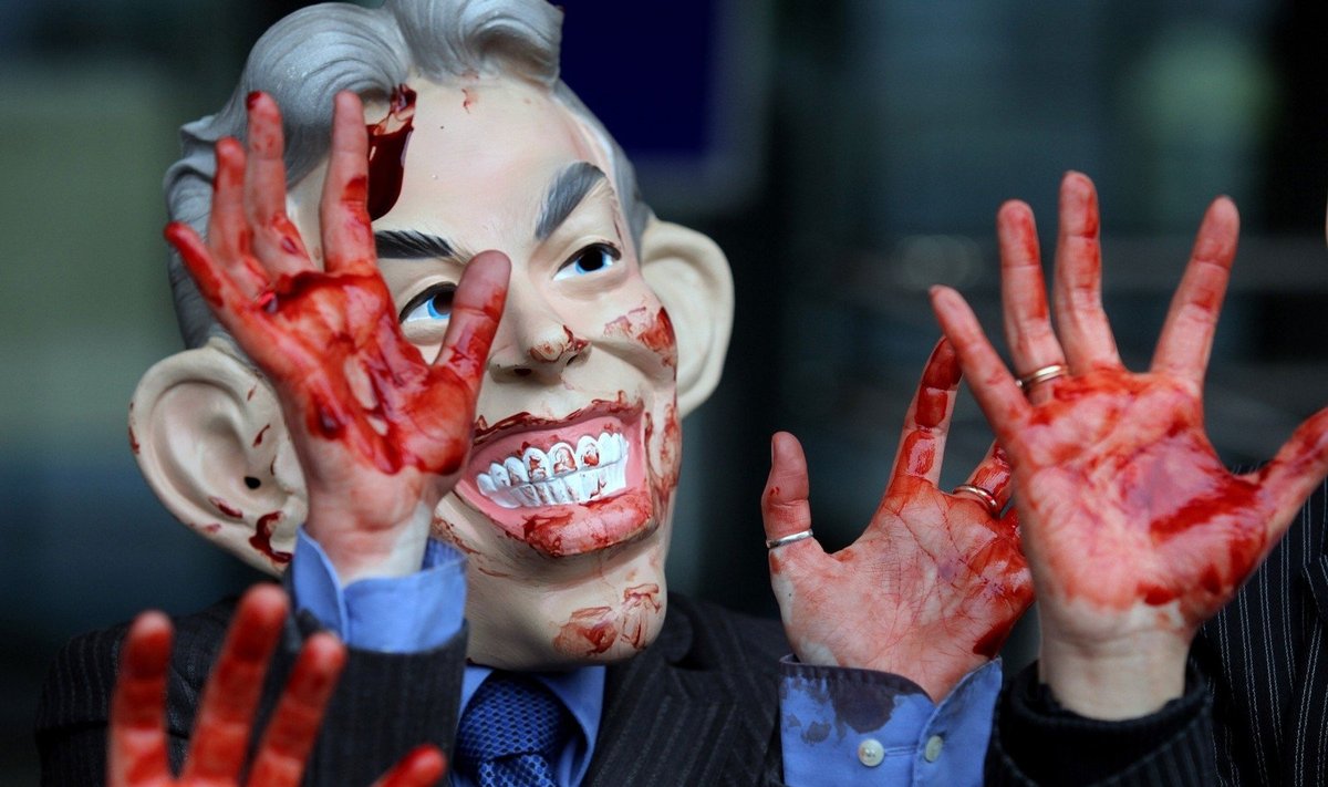 Protestuotojas dėvi Tony Blairo kaukę