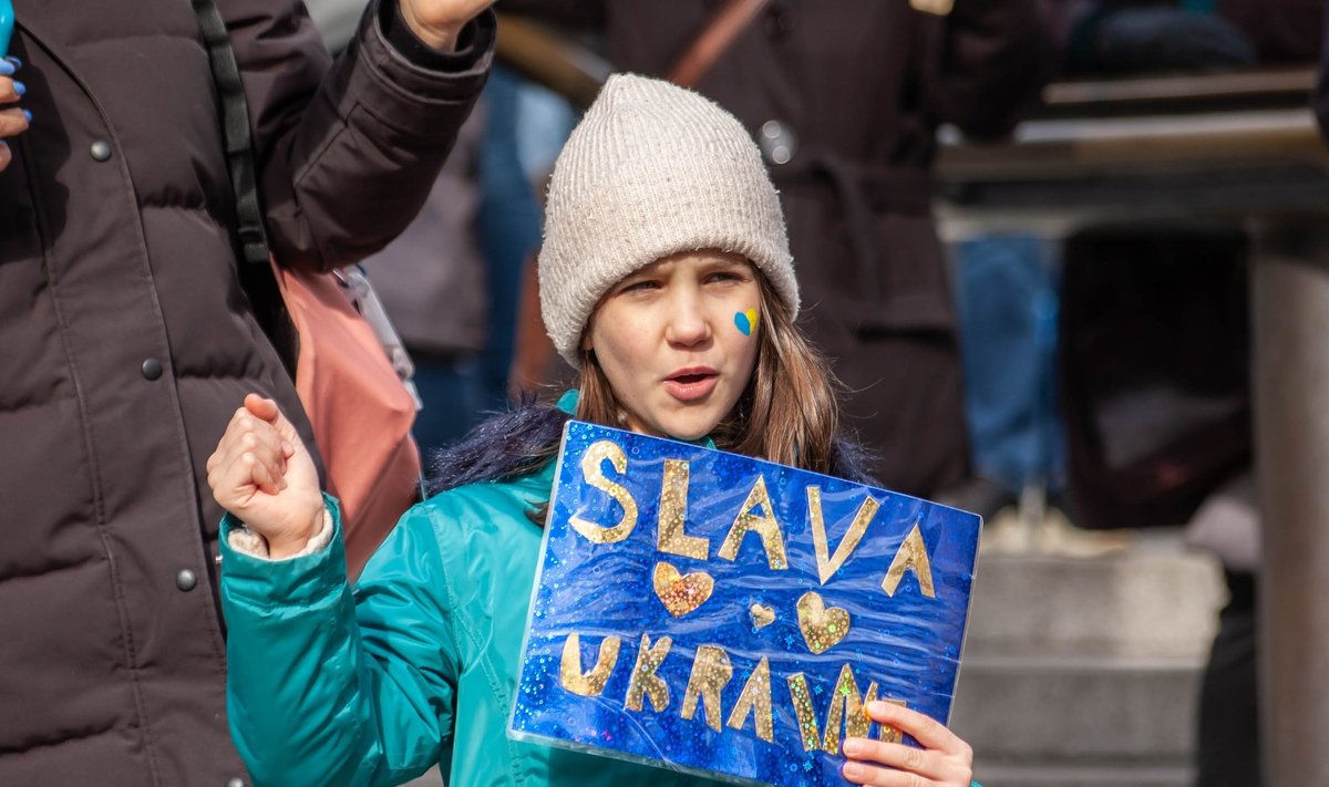LONDONAS, ANGLIJA - 2022 m. kovo 6 d.: maža mergaitė su plakatu "SLAVA UKRAINI" mitinge už Ukrainą Londone