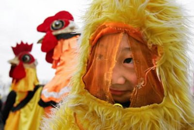 Viščiuku apsirėdęs kinų berniukas linksminasi sutikdamas Naujuosius – Gaidžio metus. 